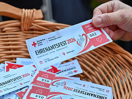 Ehrenamtsfest 2026 Eine Hand zieht ein Los mit rotem Herz aus einem geflochtenen Korb – Losziehung beim Ehrenamtsfest des DRK Tecklenburger Land.